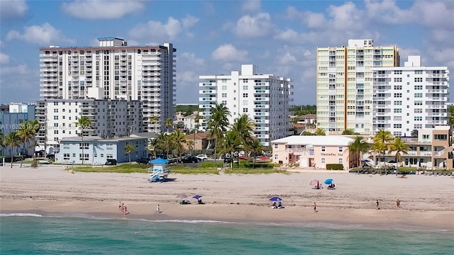 view of building exterior with a beach view and a water view