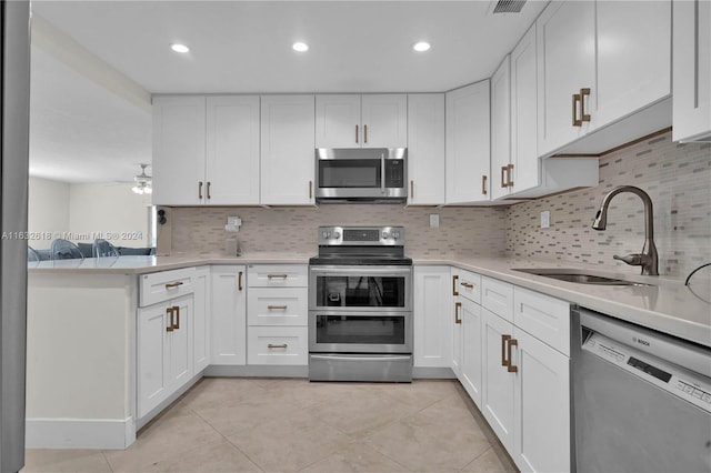 kitchen featuring white cabinets, decorative backsplash, sink, and stainless steel appliances