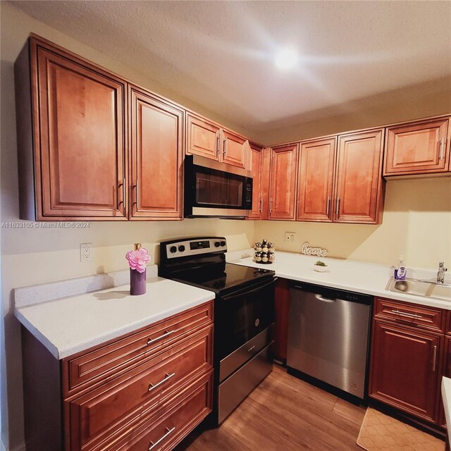 kitchen featuring appliances with stainless steel finishes, sink, and light wood-type flooring