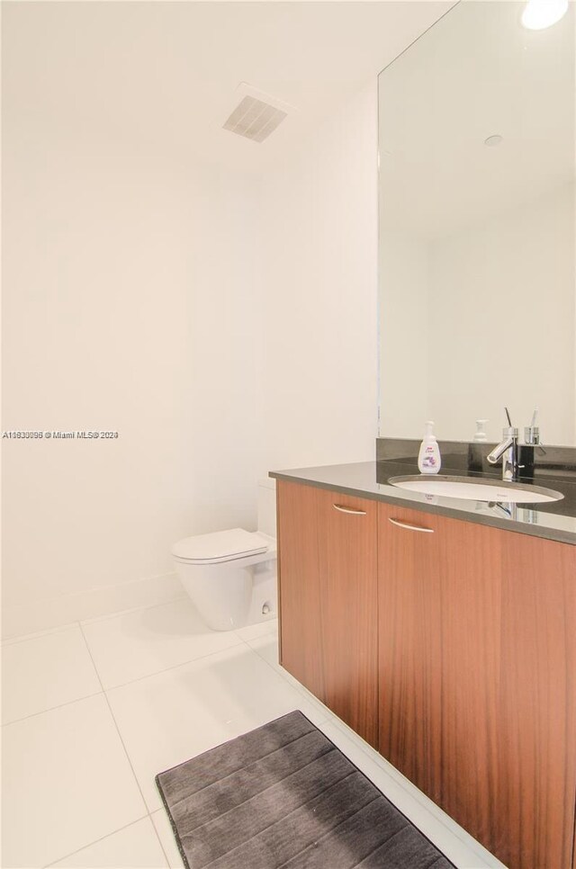 bathroom with vanity, toilet, and tile patterned flooring