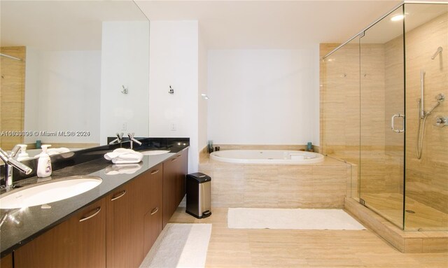 bathroom featuring shower with separate bathtub and double sink vanity