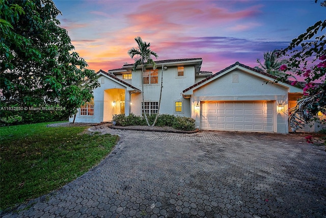 view of front of property featuring a garage and a lawn