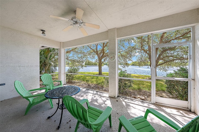 sunroom with a water view, ceiling fan, and plenty of natural light