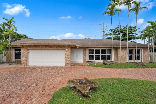 single story home featuring a front yard and a garage