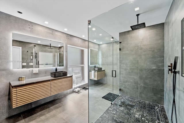 bathroom featuring a shower with door, tile walls, and vanity