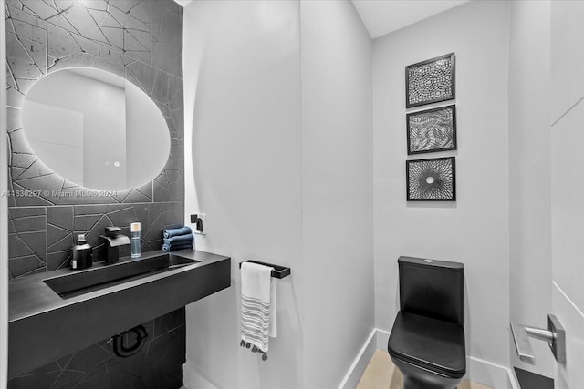 bathroom featuring toilet, tasteful backsplash, and sink