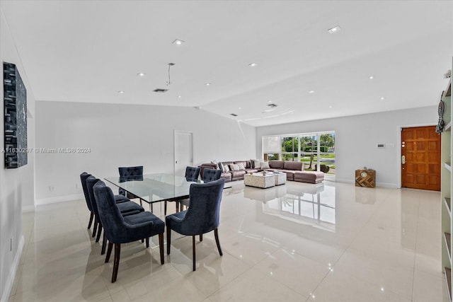 tiled dining space featuring vaulted ceiling