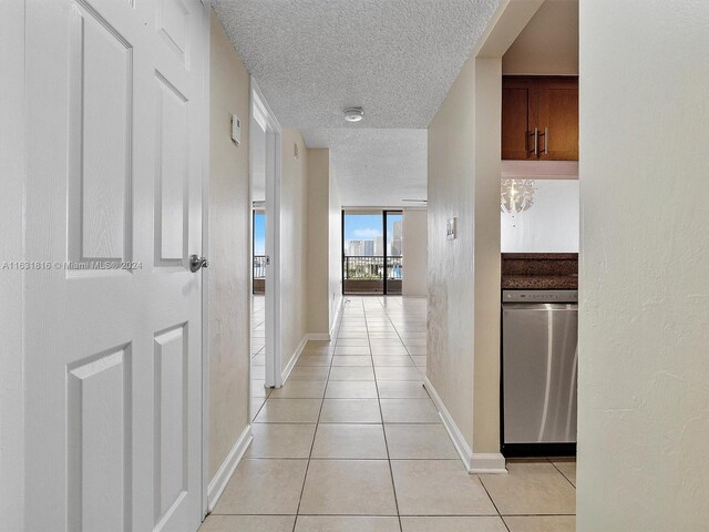 hallway featuring light tile patterned floors and a textured ceiling