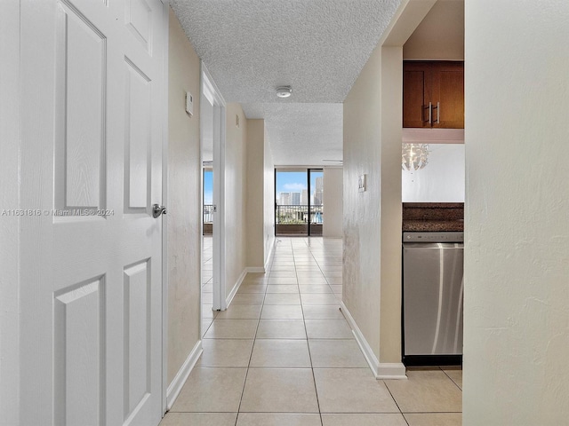 hall featuring a textured ceiling and light tile patterned floors