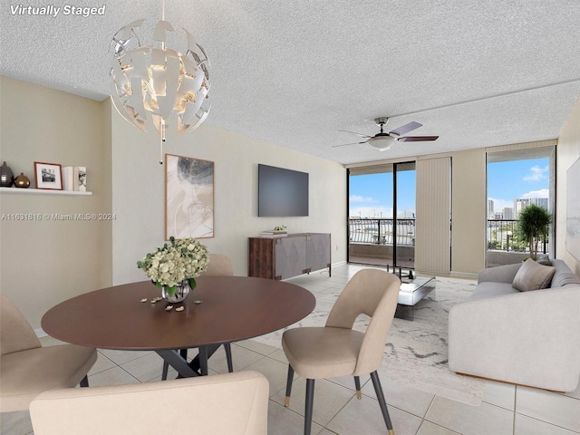 dining room featuring ceiling fan with notable chandelier, floor to ceiling windows, and a textured ceiling