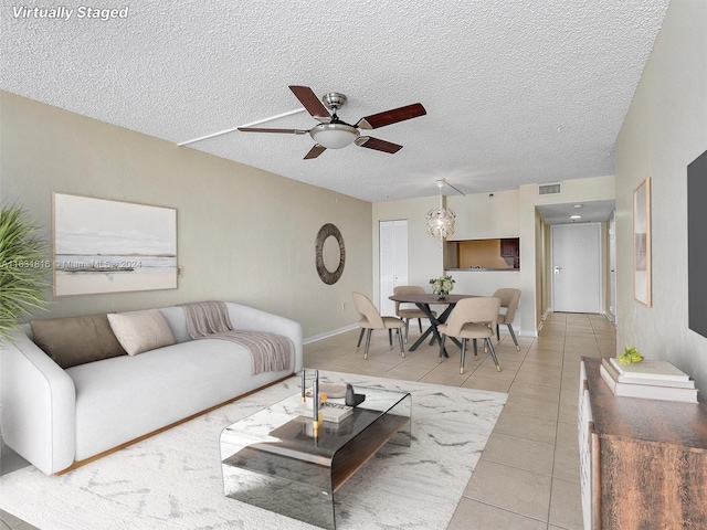 tiled living room featuring ceiling fan and a textured ceiling