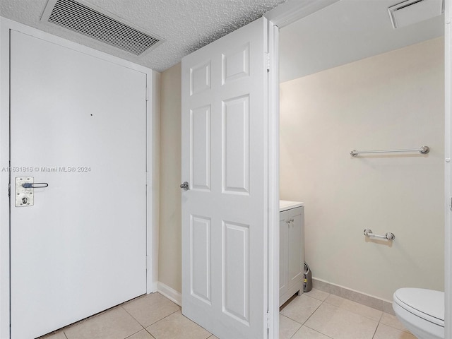 bathroom featuring tile patterned floors, a textured ceiling, and toilet