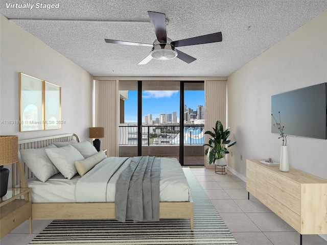 bedroom featuring ceiling fan, access to outside, a textured ceiling, and light tile patterned flooring