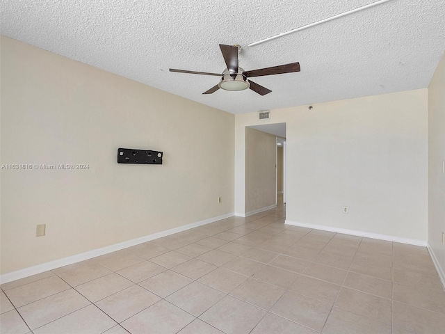 tiled empty room with a textured ceiling and ceiling fan