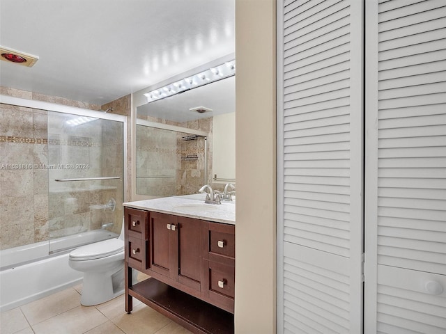 full bathroom with bath / shower combo with glass door, vanity, toilet, and tile patterned flooring