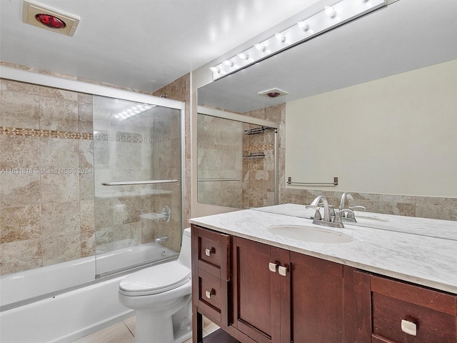 full bathroom with vanity, tile patterned floors, enclosed tub / shower combo, and toilet