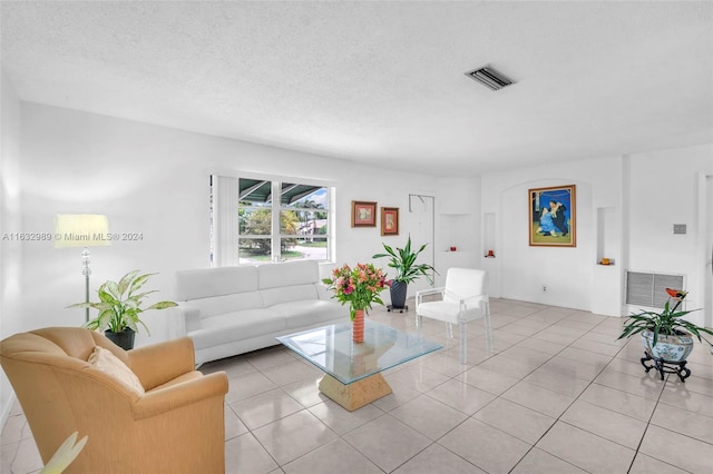 living room featuring a textured ceiling and light tile patterned floors