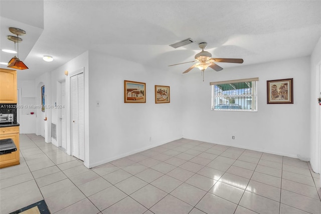 tiled empty room with ceiling fan