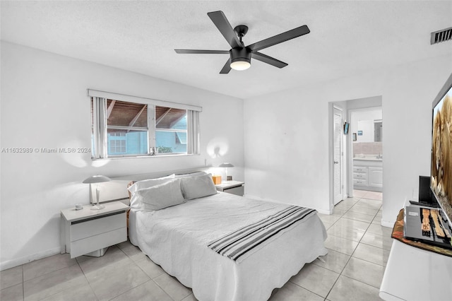 tiled bedroom featuring ensuite bathroom and ceiling fan