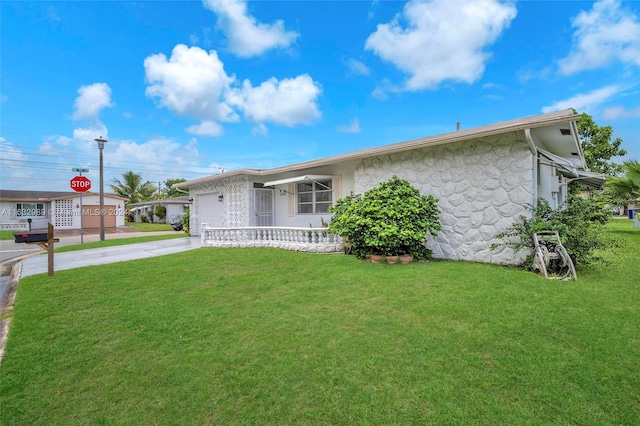 single story home with a garage and a front lawn