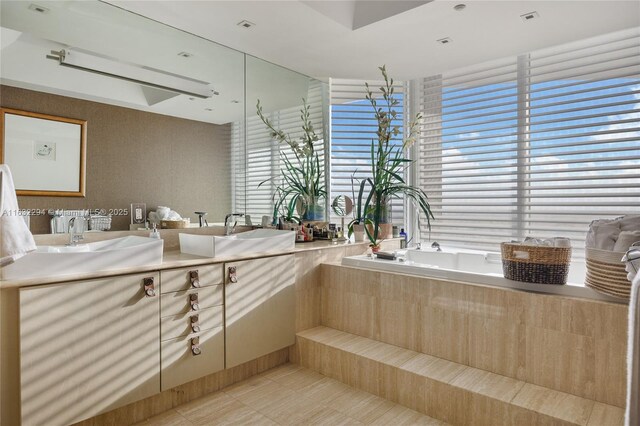 bathroom with tiled tub, tile patterned floors, and vanity