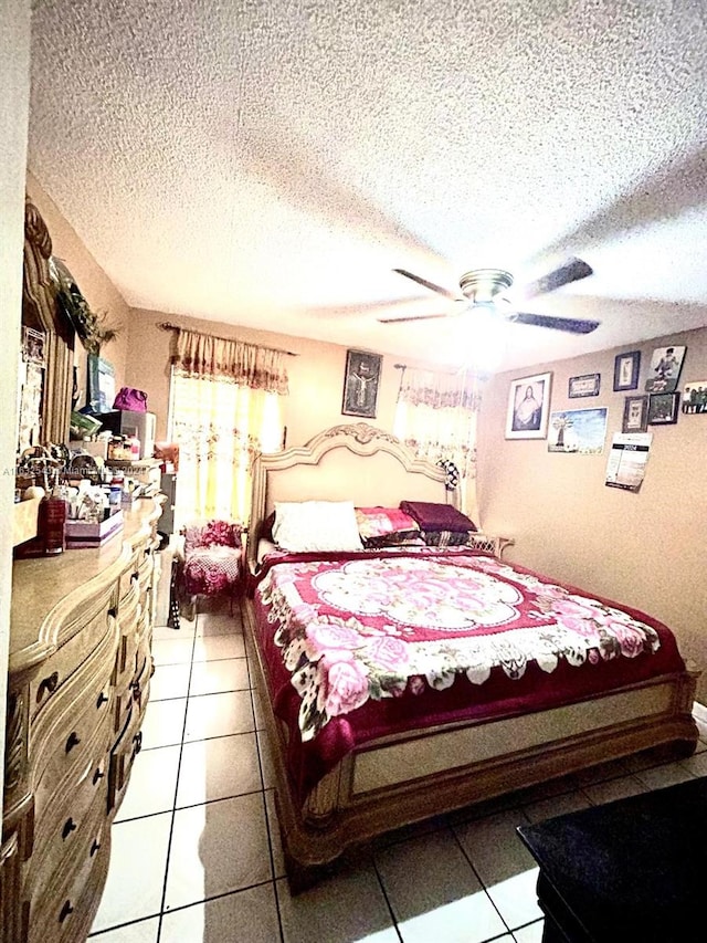 tiled bedroom featuring a textured ceiling and ceiling fan