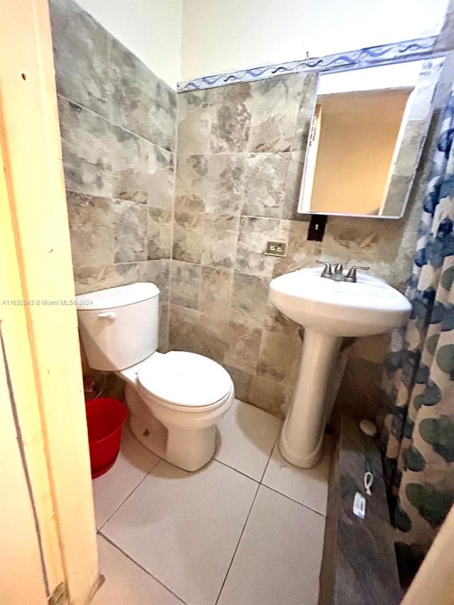 bathroom with tile walls, tile patterned floors, and toilet