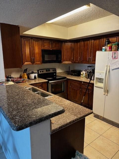 kitchen with stainless steel electric stove, white refrigerator with ice dispenser, light tile patterned floors, sink, and kitchen peninsula