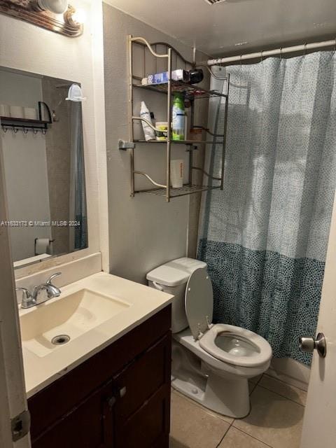 bathroom featuring toilet, vanity, and tile patterned floors