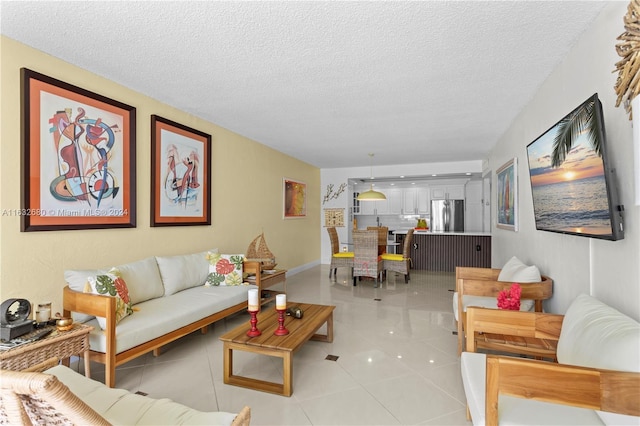 living room featuring light tile patterned flooring and a textured ceiling