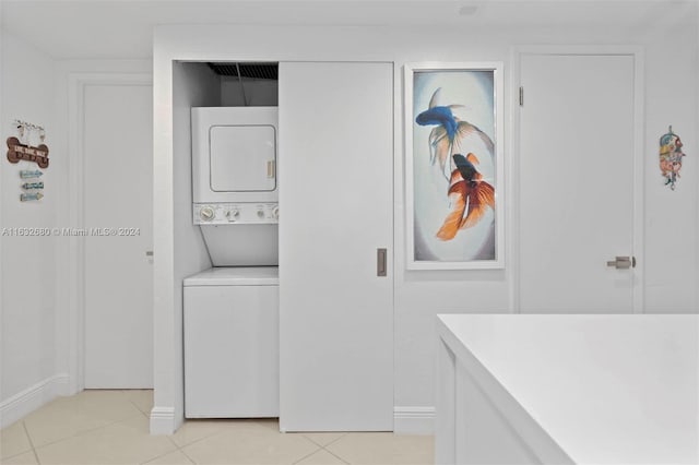 laundry room featuring light tile patterned flooring and stacked washer and clothes dryer