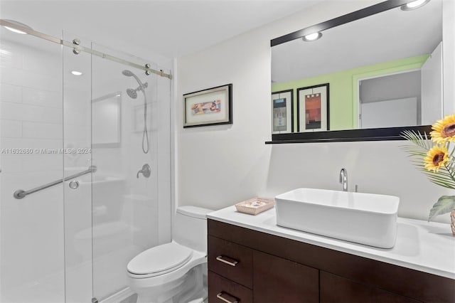 bathroom featuring vanity, an enclosed shower, and toilet