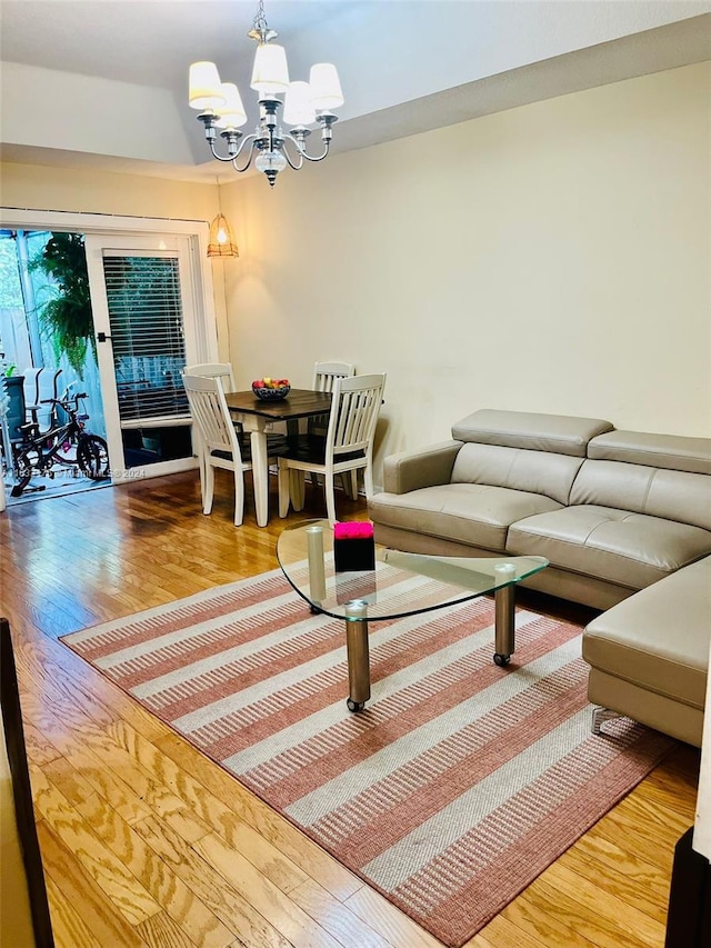 living room with light wood-type flooring and an inviting chandelier