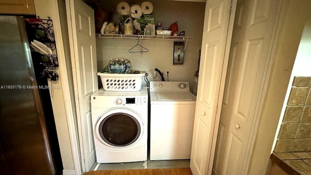 laundry area featuring washing machine and dryer and hardwood / wood-style floors