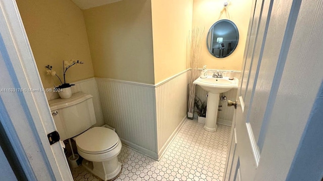 bathroom with sink, toilet, and tile patterned flooring