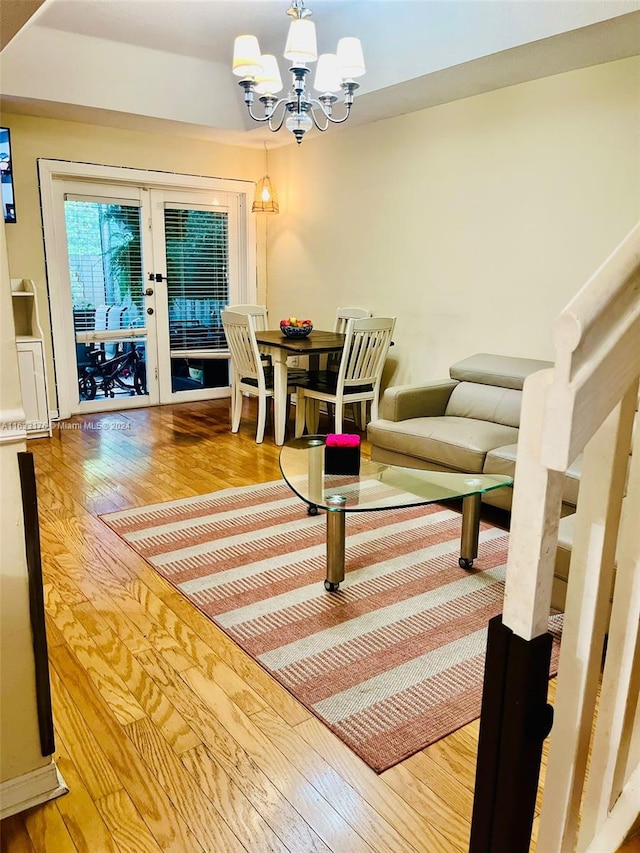 living room featuring a notable chandelier, french doors, and light hardwood / wood-style floors