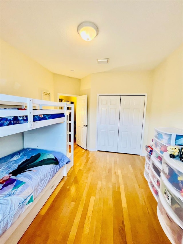 bedroom with light hardwood / wood-style flooring and a closet