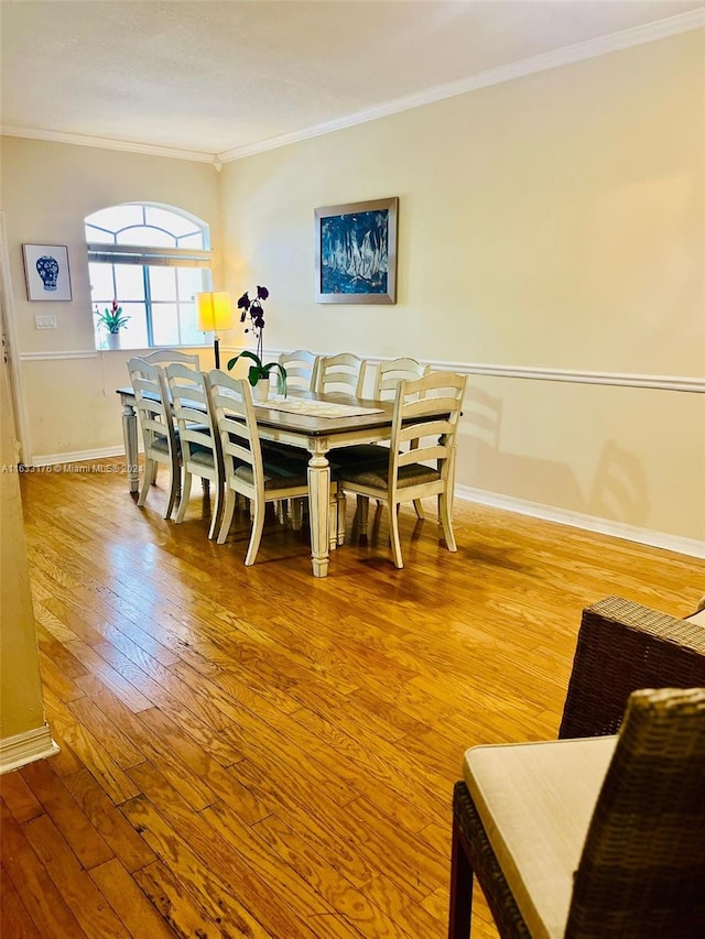 dining room featuring hardwood / wood-style floors and crown molding