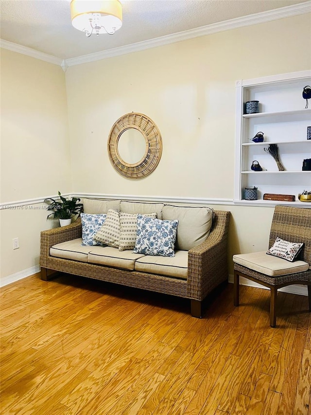 living room with a textured ceiling, ornamental molding, and hardwood / wood-style flooring