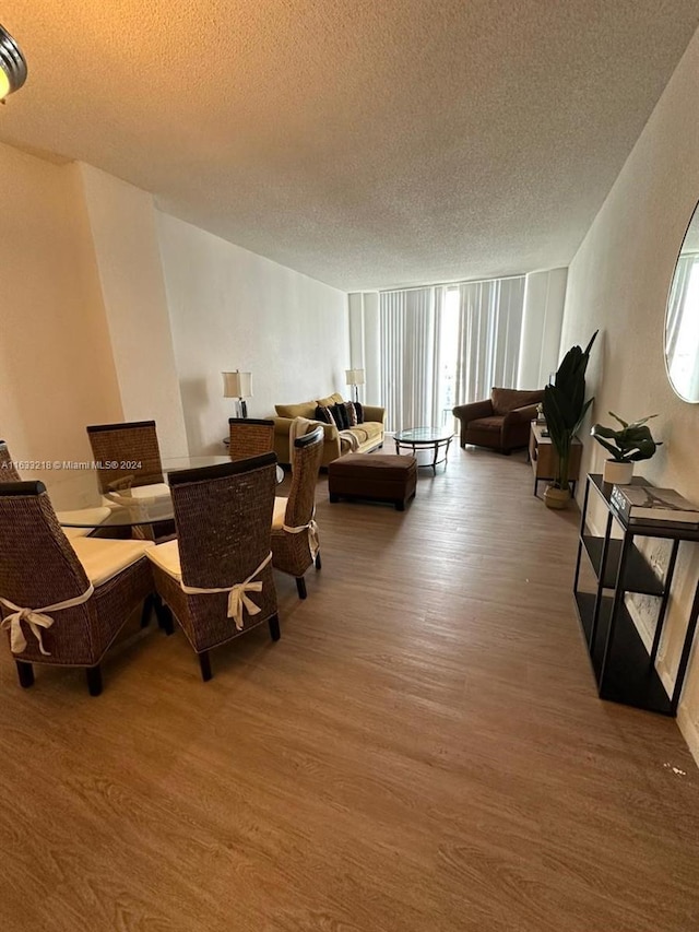 dining room featuring hardwood / wood-style flooring and a textured ceiling