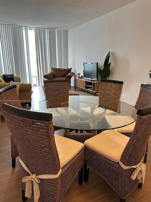 dining room with hardwood / wood-style flooring and a textured ceiling