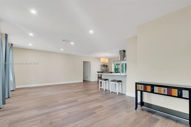 living room with light wood-type flooring and an inviting chandelier