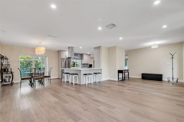 living room with light wood-type flooring and a chandelier