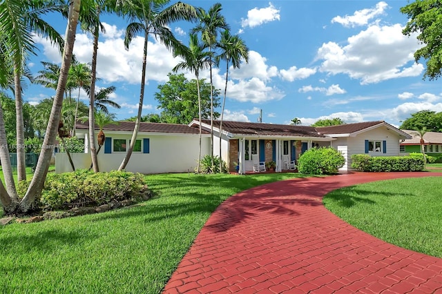 single story home with a front lawn, a tiled roof, and stucco siding