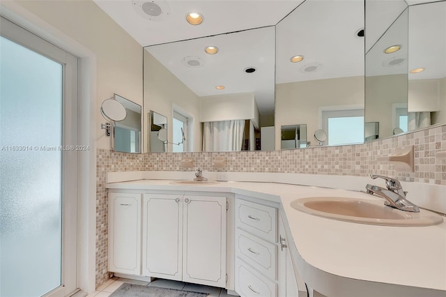 full bathroom featuring double vanity, recessed lighting, backsplash, and a sink