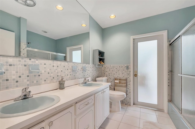 bathroom with a sink, toilet, double vanity, and tile patterned flooring