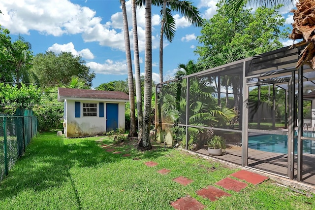 view of yard with glass enclosure, an outdoor structure, a fenced in pool, and a fenced backyard