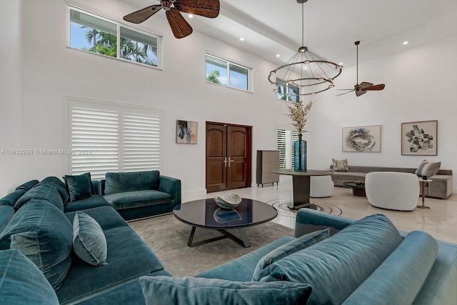 living room with ceiling fan with notable chandelier and a towering ceiling