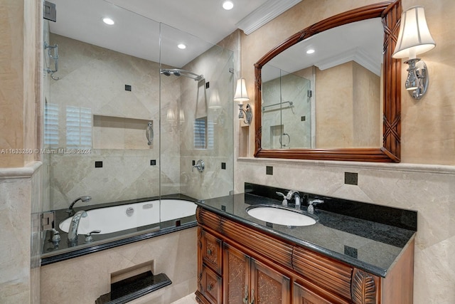 bathroom featuring tile walls, ornamental molding, bath / shower combo with glass door, and vanity