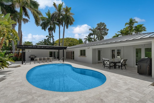 view of swimming pool featuring a patio area, grilling area, french doors, and a pergola